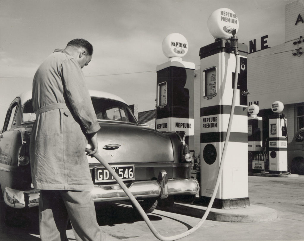 Neptune service station, man filling petrol tank in car from a Neptune Premium bowser. Author / Creator Newton, Helmut, 1920-2004, photographer. Date between 1953 and 1958. Sourced from the State Library Victoria.